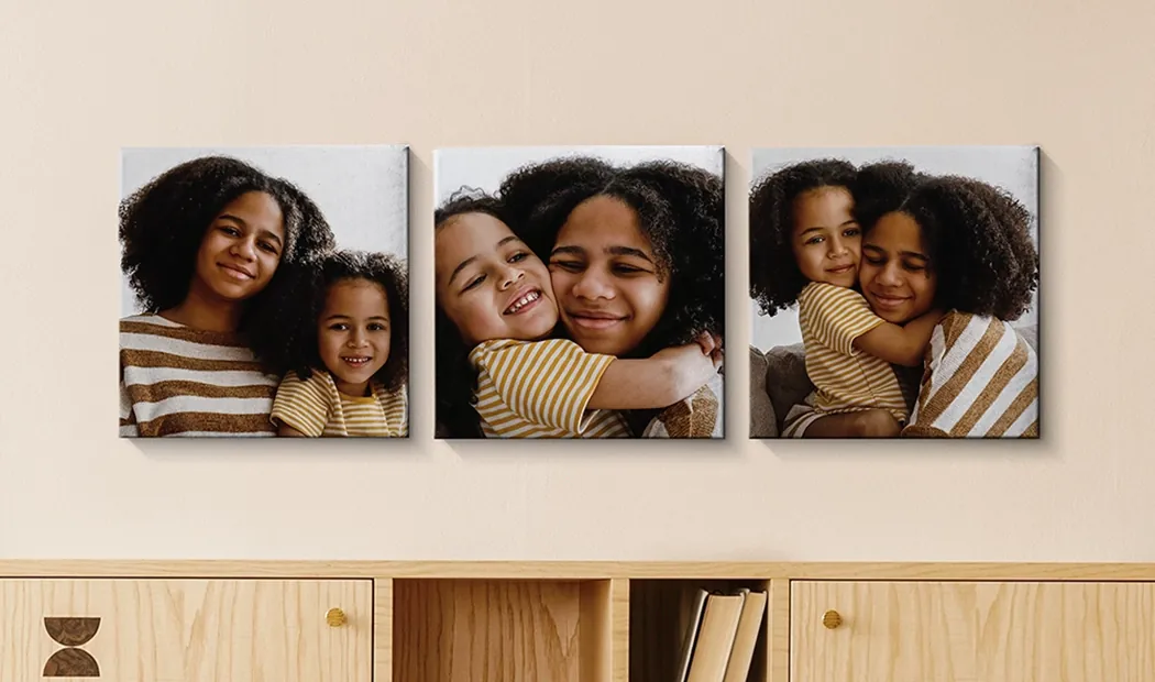 Foto-Leinwand-Display-Paneele von Printerpix|Leinwand-Paneele|Mann und Frau hängen eine Fotoleinwand mit einem Urlaubsfoto auf|Frau hängt drei schwarz-weiße Familienfotoleinwände auf|Mama und vier kleine Kinder sitzen auf dem Sofa vor vier Fotoleinwänden|Paar vor einer blauen Wand mit neun quadratischen Fotoleinwänden|||||